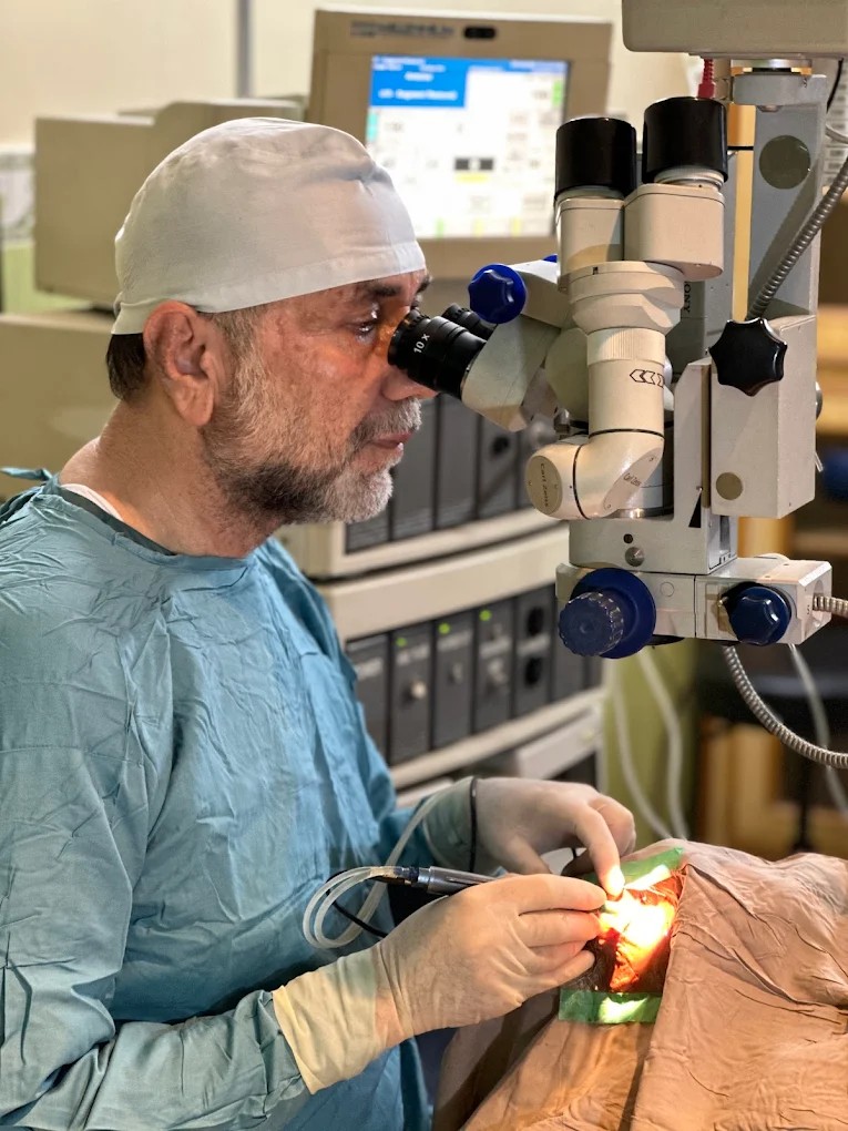 Dr. Nusrat Ullah Khan performing eye surgery with a Carl Zeiss surgical microscope