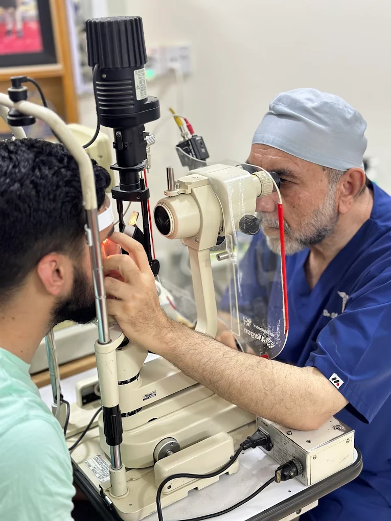 Dr. Nusrat Ullah Khan examining a patient with a slit lamp biomicroscope in clinic